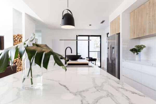 a beautifully remodeled kitchen with marble countertops and light wood cabinets