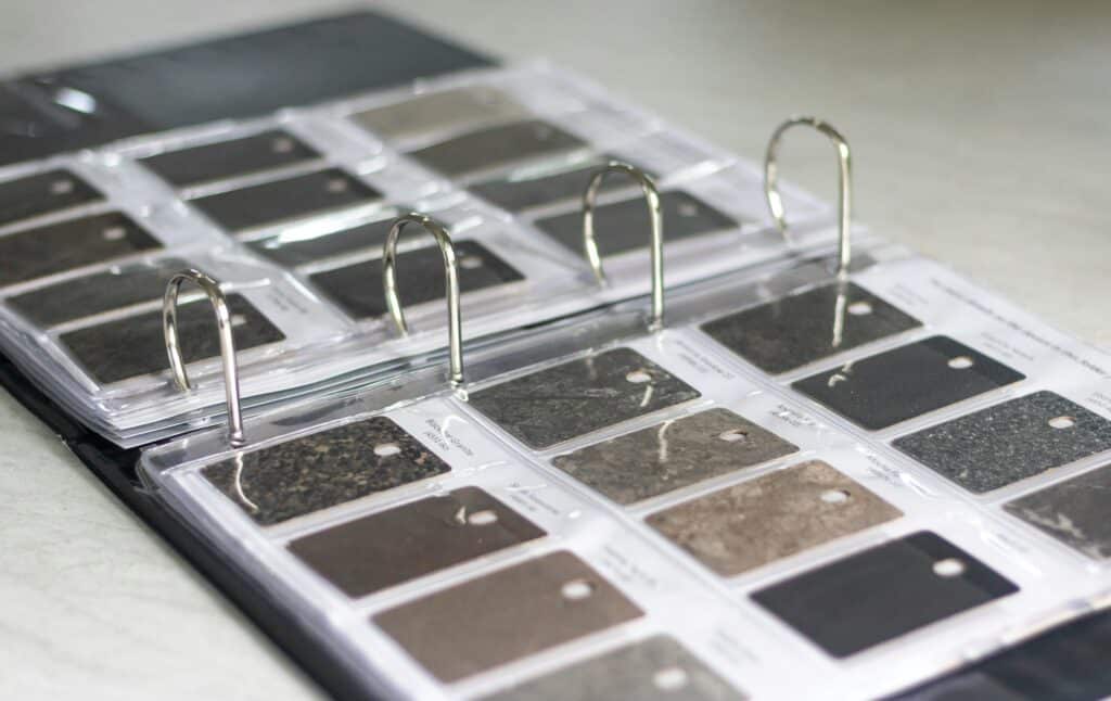 a close up on countertop options in a swatch book provided by a remodeling company